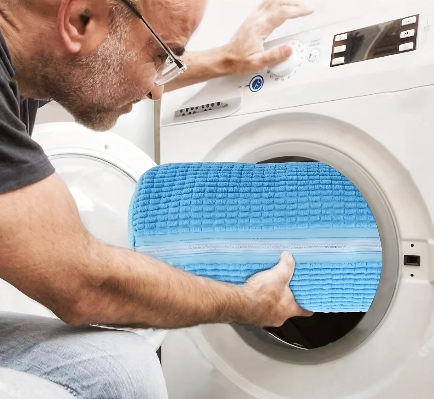 Man loading the large Sky Blue bag into a washer