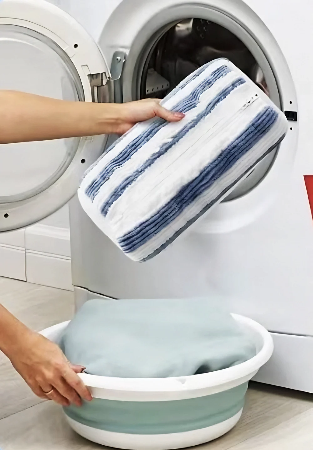 Loading a Navy Stripe bag into a front-load washer